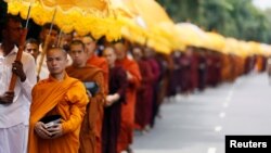 Buddhist monks walk down a road asking for alms during the annual Vesak festival, in Colombo, Sri Lanka, May 11, 2017. 