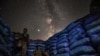 The Milky Way galaxy is seen in the sky above Syrian fighters of the Turkish-backed National Front for Liberation group while on watch duty in the town of Taftanaz along the frontlines in the rebel-held northwestern Idlib province.