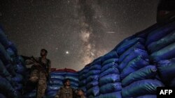 The Milky Way galaxy is seen in the sky above Syrian fighters of the Turkish-backed National Front for Liberation group while on watch duty in the town of Taftanaz along the frontlines in the rebel-held northwestern Idlib province.