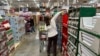 Shoppers reach for items on display in a Costco warehouse, Nov. 19, 2024, in Lone Tree, Colorado.