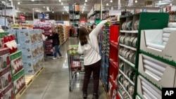 Shoppers reach for items on display in a Costco warehouse, Nov. 19, 2024, in Lone Tree, Colorado.