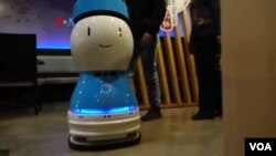 Robot pelayan menyambut tamu dan mengantar makanan di restoran. (Foto: VOA)