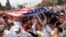 Immigration reform demonstrators carry a U.S. flag as they chant slogans during a mass rally for comprehensive immigration policy reform on the Washington Mall, March 21, 2010.