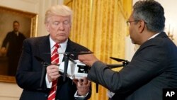 George Mathew, CEO of Kespry, shows a drone to President Donald Trump during the "American Leadership in Emerging Technology" event in the East Room of the White House, June 22, 2017, in Washington.