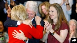 Democratic presidential candidate Hillary Clinton hugs former President Bill Clinton alongside their daughter Chelsea during a caucus night rally at Drake University in Des Moines, Iowa, Monday, Feb. 1, 2016. (AP Photo/Patrick Semansky)