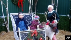 Jingles the reindeer poses with owner Sonya Benhardt and young fans at Swanson's Nursery in Seattle, Washington.