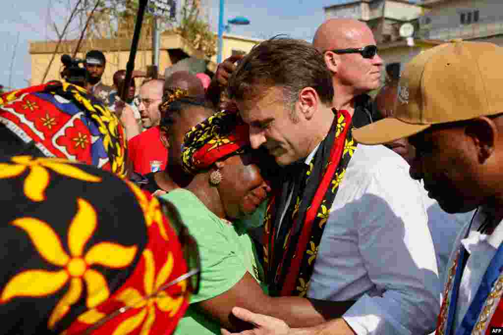 France&#39;s president Emmanuel Macron embraces a woman as he speaks with local residents during his visit at the kavani district in Mamoudzou, on the French Indian Ocean territory of Mayotte, aftermath of the cyclone Chido.