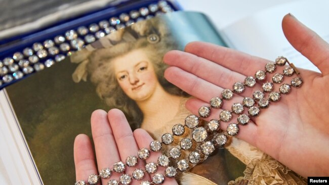 FILE - A staff member displays a pair of diamond bracelets, with approximately 140 to 150 carats and owned by Queen Marie Antoinette of France, in silver and yellow gold, circa 1776, during a preview at Christie's before their auction sale in Geneva, Nov. 3, 2021.