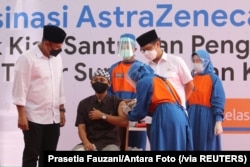 Seorang santri Pesantren Lirboyo sedang disuntik vaksin COVID-19 buatan AstraZeneca, di Kediri, Jawa Timur, 23 Maret 2021. (Foto: Prasetia Fauzani/Antara Foto via Reuters)