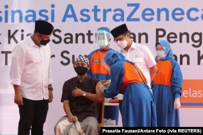 Seorang santri Pesantren Lirboyo sedang disuntik vaksin COVID-19 buatan AstraZeneca, di Kediri, Jawa Timur, 23 Maret 2021. (Foto: Prasetia Fauzani/Antara Foto via Reuters)