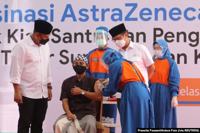 Seorang santri Pesantren Lirboyo sedang disuntik vaksin COVID-19 buatan AstraZeneca, di Kediri, Jawa Timur, 23 Maret 2021. (Foto: Prasetia Fauzani/Antara Foto via Reuters)