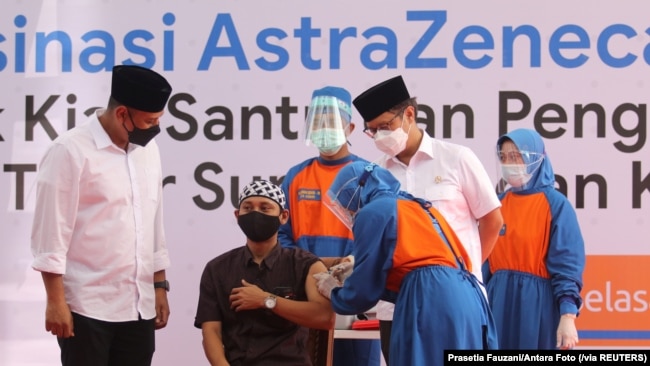 Seorang santri Pesantren Lirboyo sedang disuntik vaksin COVID-19 buatan AstraZeneca, di Kediri, Jawa Timur, 23 Maret 2021. (Foto: Prasetia Fauzani/Antara Foto via Reuters)