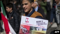 Un manifestant tient un panneau indiquant "Libérez les travailleurs emprisonnés en Iran" lors d'un rassemblement en Suède, à Stockholm, le 1er mai 2018.