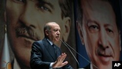 Backdropped by pictures of himself (R) and modern Turkey's founder Mustafa Kemal Ataturk (L),Turkey's President Recep Tayyip Erdogan addresses officials of his ruling Justice and Development Party (AKP), in Ankara, Turkey, Sept. 14, 2018.