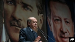 Backdropped by pictures of himself (R) and modern Turkey's founder Mustafa Kemal Ataturk (L),Turkey's President Recep Tayyip Erdogan addresses officials of his ruling Justice and Development Party (AKP), in Ankara, Turkey, Sept. 14, 2018.