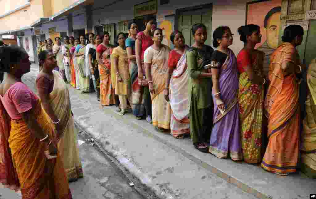 Women stand in line to cast their votes at a polling booth in Howrah district, on the outskirts of Kolkata, April 30, 2014. 