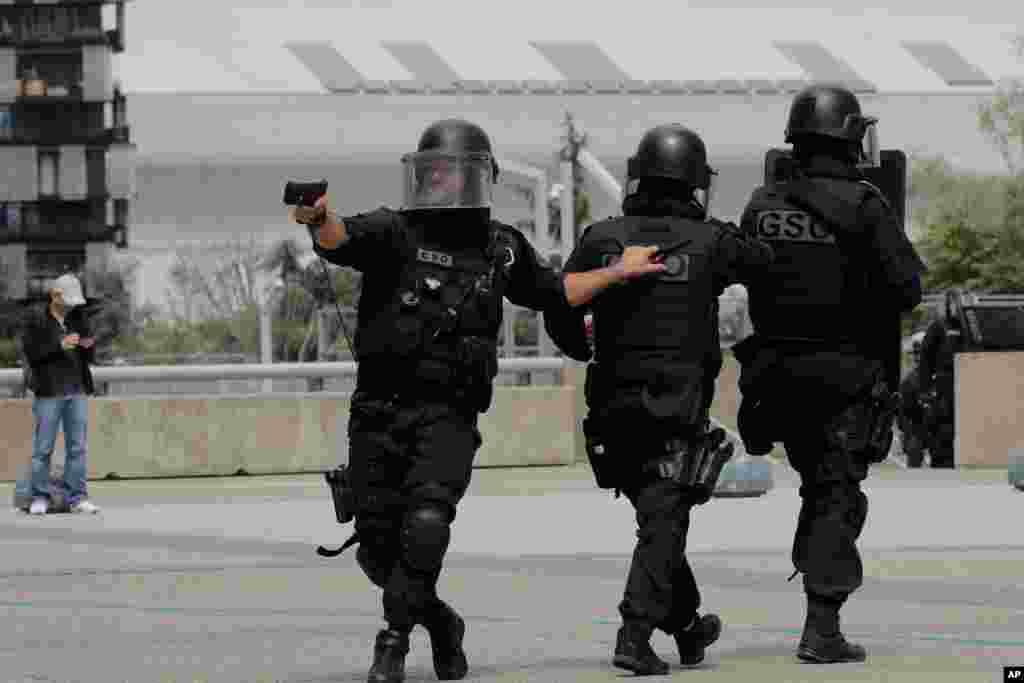 French police officers patrol in the business district of La Defense outside Paris, France. Police say checks have been completed and a witness’s report of seeing a man carrying a gun turned out to be an apparent false alarm.