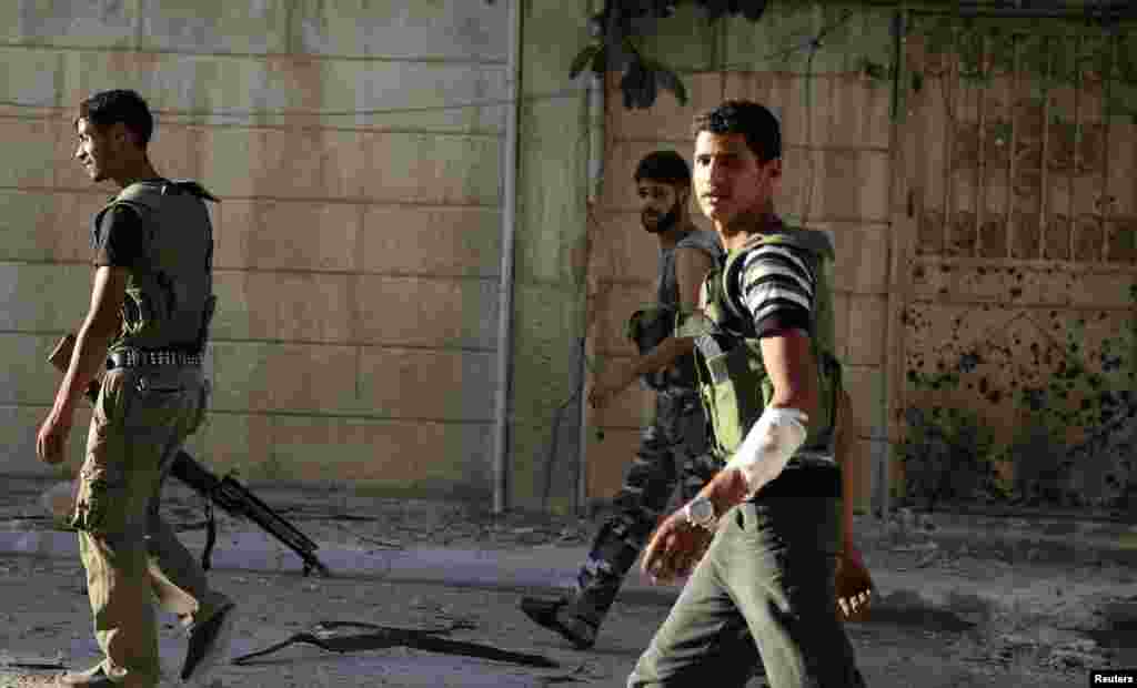 Members of the Free Syrian Army walk with their weapons in Harasta area in Damascus, July 13, 2013.&nbsp;