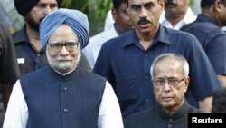 India's Prime Minister Manmohan Singh, left, poses for a picture with the newly elected President Pranab Mukherjee in New Delhi, July 22, 2012. 