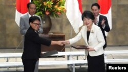 2023年12月16日，日本外相上川洋子和印度尼西亞外長蕾特諾在日本東京首相官邸舉行的文件交換儀式上握手。(路透社）