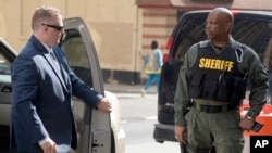 Officer Garrett Miller, left, one of the six members of the Baltimore Police Department charged in connection to the death of Freddie Gray, arrives at a courthouse for his pre-trial proceedings in Baltimore, July 27, 2016.