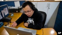 FILE - Chinese journalist Li Xin talks to an Associated Press reporter over Skype, at the AP office in New Delhi, India, Nov. 20, 2015.