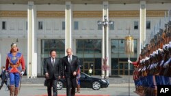 Le président russe Vladimir Poutine, à droite, son homologue mongol, le président Elbegdorj Tsakhia, au milieu et un garde d'honneur en tenue traditionnelle à la place Genghis Khan à Oulan Bator en Mongolie, 3 septembre, 2014.