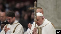 Pope Francis holds the cross as he presides over an Epiphany mass in St. Peter's Basilica at the Vatican, Jan. 6, 2025. Francis named an Italian nun, Sister Simona Brambilla, to head a major Vatican office.