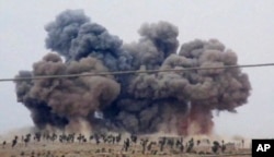 FILE - In this image made from video provided by Hadi Al-Abdallah, which has been verified and is consistent with other AP reporting, smoke rises after airstrikes in Kafr Nabel of the Idlib province, western Syria, Oct. 1, 2015.