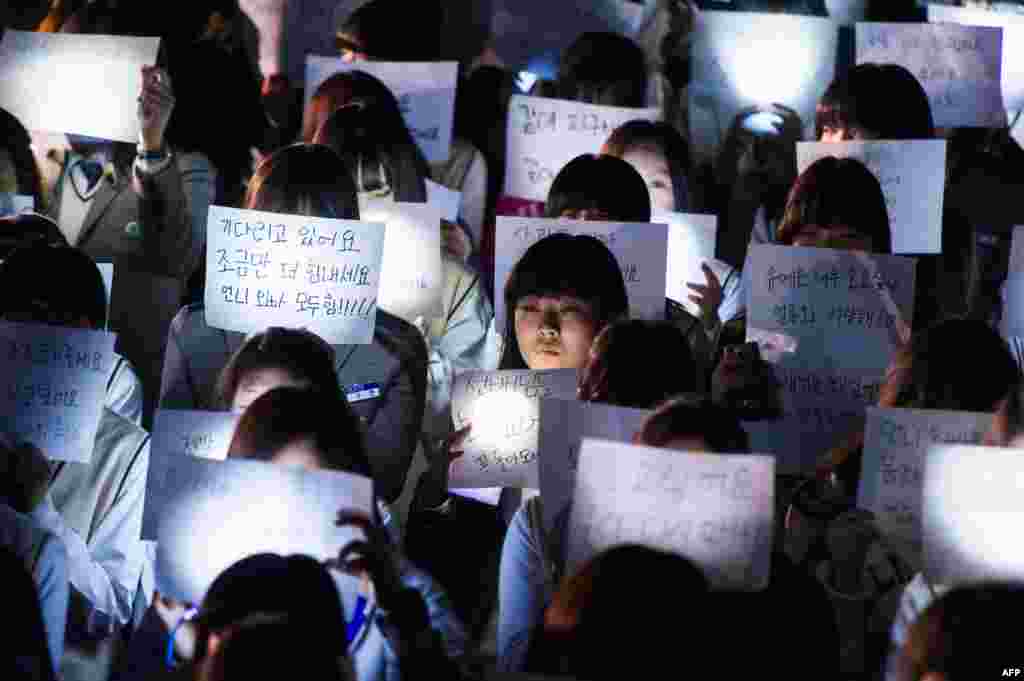 Học sinh trường Trung học Danwon ở Ansan cầm những biểu ngữ với thông điệp dành cho những học sinh trong số những hành khách bị mắc kẹt trong chiếc phà bị lật ở Hàn Quốc.