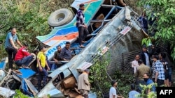 This handout photograph taken and released on Nov. 4, 2024, by the Department of Information and Public Relations Uttarakhand shows people at the site of a bus accident, after it fell into a gorge at Almora district in India's Uttarakhand state.