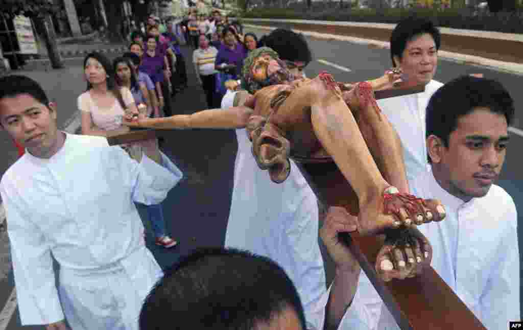 An effigy of Jesus Christ on the cross is carried by devotees during a Good Friday procession in Manila, The Philippines, April 3, 2015. 