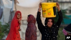A woman carries water for her family at a tube well in Rawalpindi, Pakistan, Aug. 22, 2017. A new study suggests some 50 million Pakistanis could be at risk of drinking arsenic-tainted groundwater. The findings are based on a hazard map built using water quality data from 1,200 tube wells in the densely populated Indus Valley.