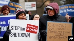 People rally to call for an end to the partial government shutdown in Detroit, Thursday, Jan. 10, 2019.