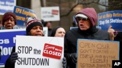 People rally to call for an end to the partial government shutdown in Detroit, Thursday, Jan. 10, 2019.