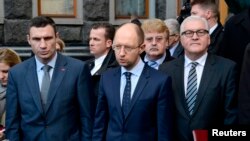 Menteri Luar Negeri Jerman Frank-Walter Steinmeier (kanan) bersama pemimpin oposisi Ukraina Vitaly Klitschko (kiri) dan Arseny Yatsenyuk setelah penandatanganan perjanjian damai dengan Presiden Viktor Yanukovych (21/2). (Reuters/Maks Levin)