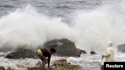 Angin kencang yang dibawa Topan Goni memicu ombak besar di pantai Manila (22/8). (Reuters/Romeo Ranoco)