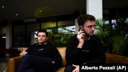 Co-founders of the app Stint, brothers Sam, left, and Sol Schlagman, sitting at their headquarters in Camden, London, Monday, Aug. 23, 2021. (AP Photo/Alberto Pezzali)