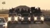 FILE - A screen grab taken from a video released by Islamic State group's official Al-Raqqa site allegedly shows IS recruits riding on trucks. Hundreds of members of the North Caucasus diaspora in Europe are thought to have gone to the Middle East to fight in the ranks IS militants.