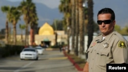 FILE - A police officer stands guard at the Dar Al Uloom Al Islamiyah-Amer mosque — where Syed Rizwan Farook was often seen — in San Bernardino, California, Dec. 4, 2015, two days after Farook and his wife shot 14 people to death at a Christmas party. 