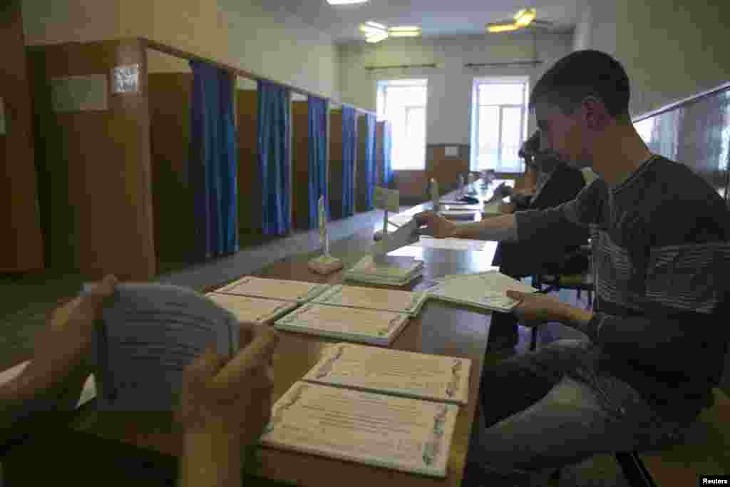 Petugas komisi pemilu menghitung kertas suara di sebuah TPS sebelum dilakukannya referendum, Minggu di Slovyansk, Ukraina (10/5).