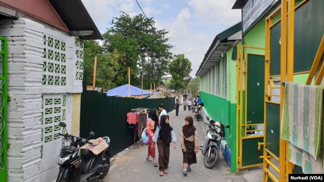 SDN Bangunrejo 1 (kanan) dan lokasi pembangunan SDN Bangunrejo 2 (kiri) di tengah perkampungan padat. (Foto: VOA/ Nurhadi)