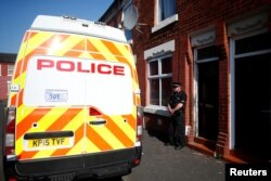 A police officer stand outside a property in Moss Side, following overnight raids in Manchester, Britain, May 25, 2017.