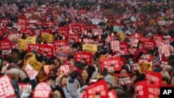 South Korean protesters hold placards during a rally calling for South Korean President Park Geun-hye to step down in Seoul, South Korea, Nov. 26, 2016.The signs read "Park Geun-hye, Step down."