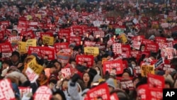 Demonstran Korea Selatan membawa poster saat berdemo menuntut Presiden Korea Selatan Park Geun-hye turun di Seoul, Korea Selatan, Sabtu, 25 November 2016.