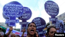 Para anggota Partai Perempuan Gabriela, kelompok yang mengadvokasi hak perempuan Filipina, menyerukan keadilan bagi pembunuhan transgender Jennifer Laude dalam protes di luar gedung kehakiman di Olongapo, Filipina (21/10).