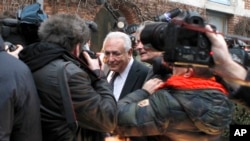 FILE - Former International Monetary Fund chief Dominique Strauss-Kahn is surrounded by photographers as he leaves for court for his trial on sex offense charges, including the alleged procurement of prostitutes, in Lille, France, Feb. 17, 2015.