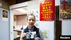 Karen Short, wife of Australian missionary John Short, poses with a photo of her husband inside the Christian Book Room in Hong Kong, Feb. 20, 2014. (Reuters)