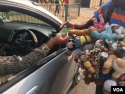 A vendor sells dolls at an intersection in central Harare, Zimbabwe, Oct. 2017. (S. Mhofu/VOA)