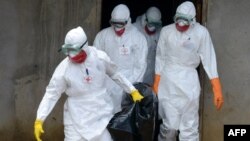 Medical workers of the Liberian Red Cross, wearing a protective suit, carry the body of a victim of the Ebola virus in a bag on Sept. 4, 2014 in the small city of Banjol, 30 kilometers from Monrovia. 